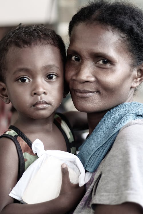 A Woman Carrying a Young Boy