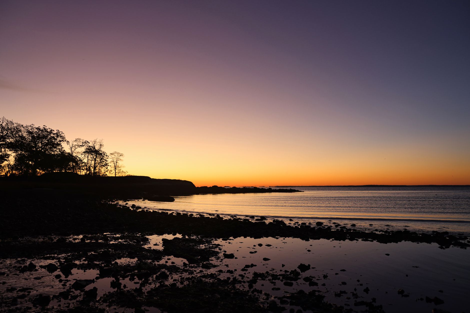 Peaceful sunset over the ocean at Cove Island Park, Stamford, CT, showcasing vibrant twilight hues.