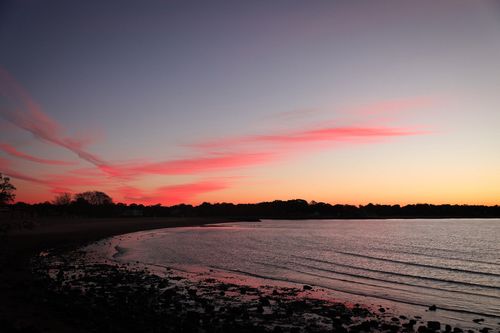 Free Dramatic sunset with pink clouds over Stamford shoreline captured in vibrant colors. Stock Photo