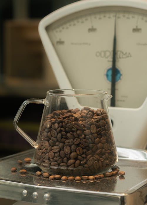 Pitcher with Coffee Beans on Weight Scale
