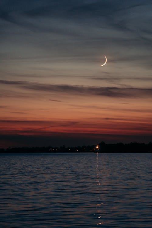 Crescent Moon on Gray Clouds During Sunset