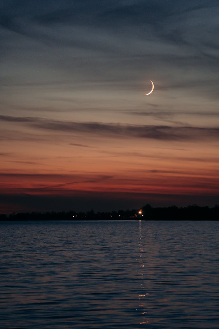 Crescent Moon On Gray Clouds During Sunset