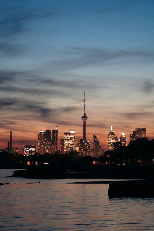 Free View of Toronto skyline at dusk featuring the iconic CN Tower with a colorful sky. Stock Photo
