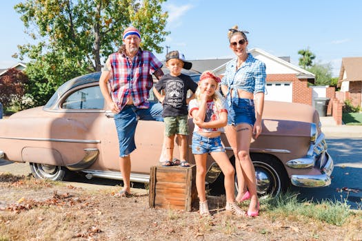 A cheerful family in casual attire posing with a classic vintage car, exuding a nostalgic charm.