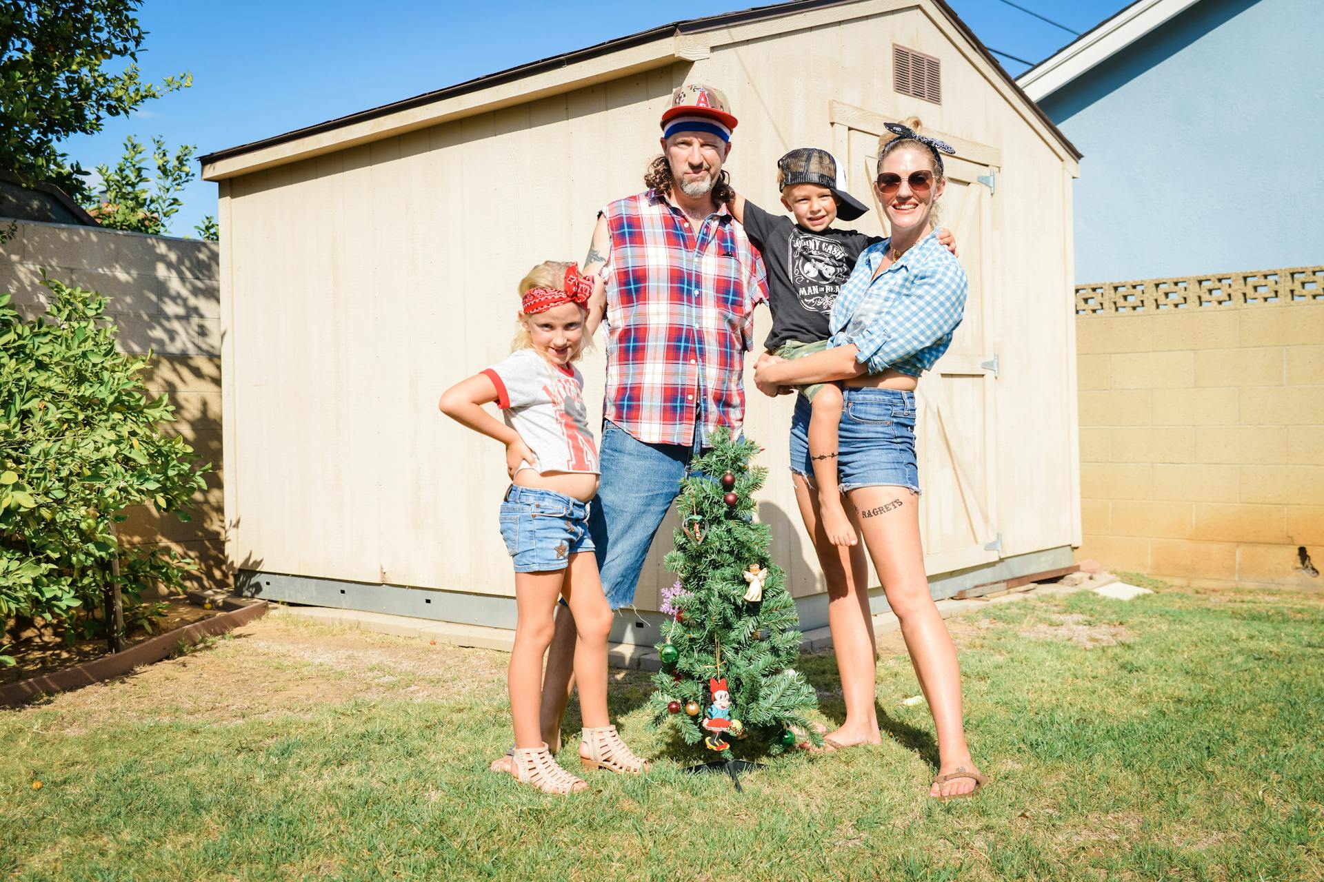 En söt familj som står vid ett litet julgran