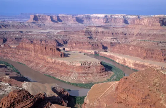 A kayak on the Colorado River beneath red cliffs near Moab, Utah