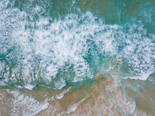 Aerial surf breaking on a sandbar, by Damon Hall on Pexels