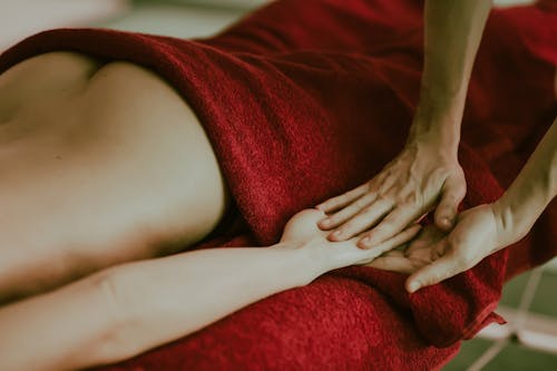 Closeup of a Person Covered with a Red Towel Getting a Massage