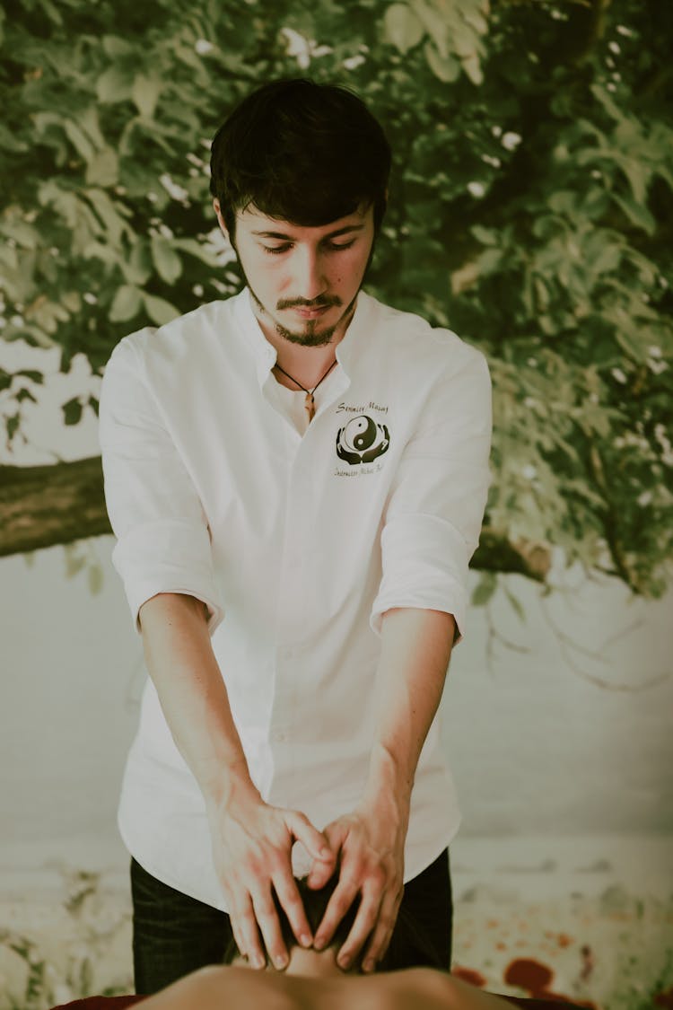 Massage Therapist Working With A Patient, And Tree In Background