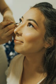 Close-up of a woman having eye makeup applied for a special occasion.