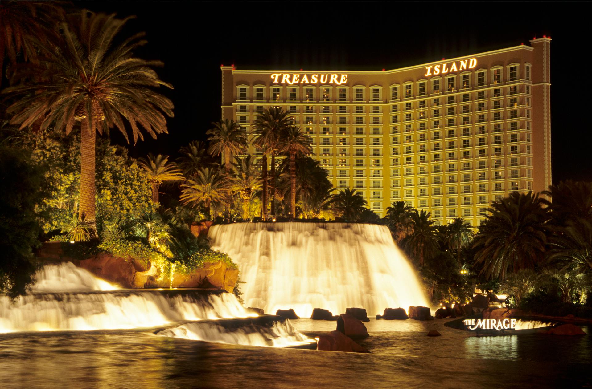 A stunning nighttime view of Treasure Island Hotel and waterfall in Las Vegas, perfect for travel and tourism visuals.