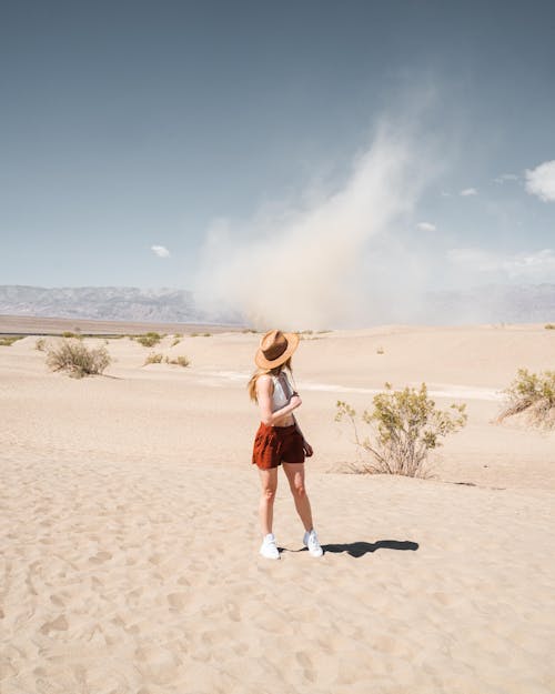 Woman Wearing a Red skirt and Brown hat in the Desert