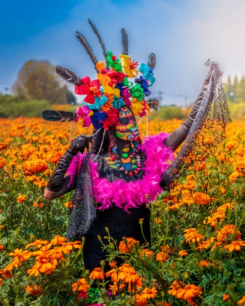 A Woman in Purple Feather Boa and Black Dress Posing in Flower Field