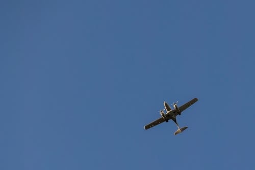 A Flying Airplane Under Blue Skies