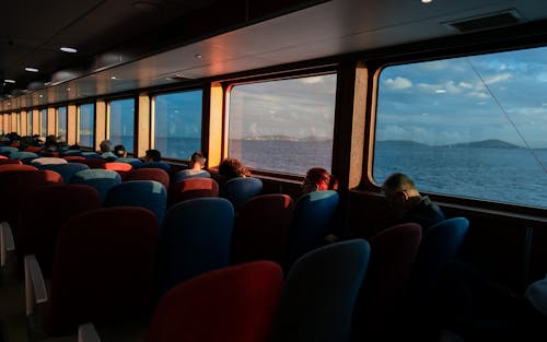 A Group of People Sitting on a Red and Blue Ferry Seat