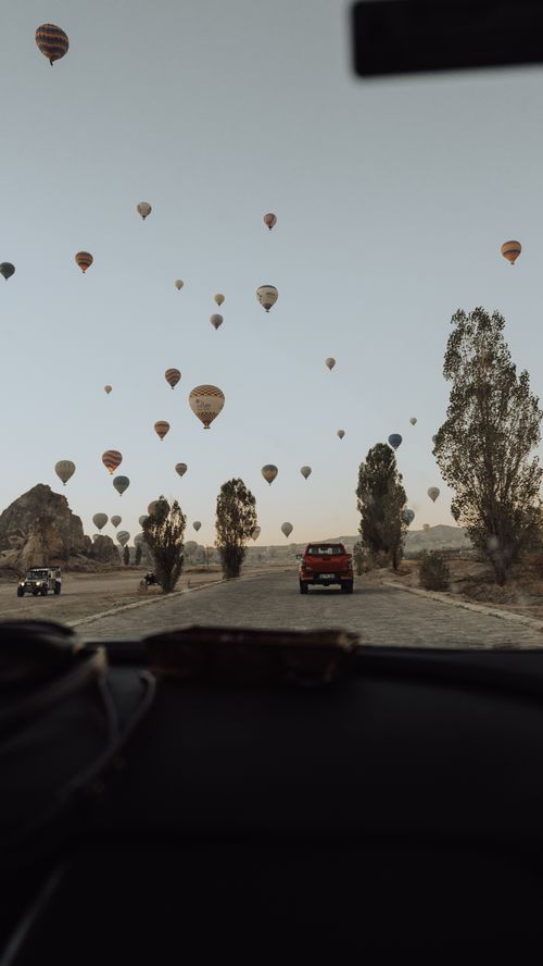 Free A scenic view of hot air balloons floating over Göreme, Turkey, captured from a car. Stock Photo