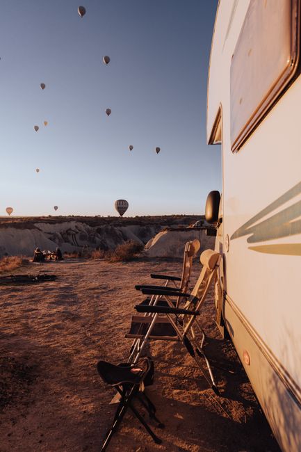 A quiet RV campsite on public land at sunset with mountains in the distance