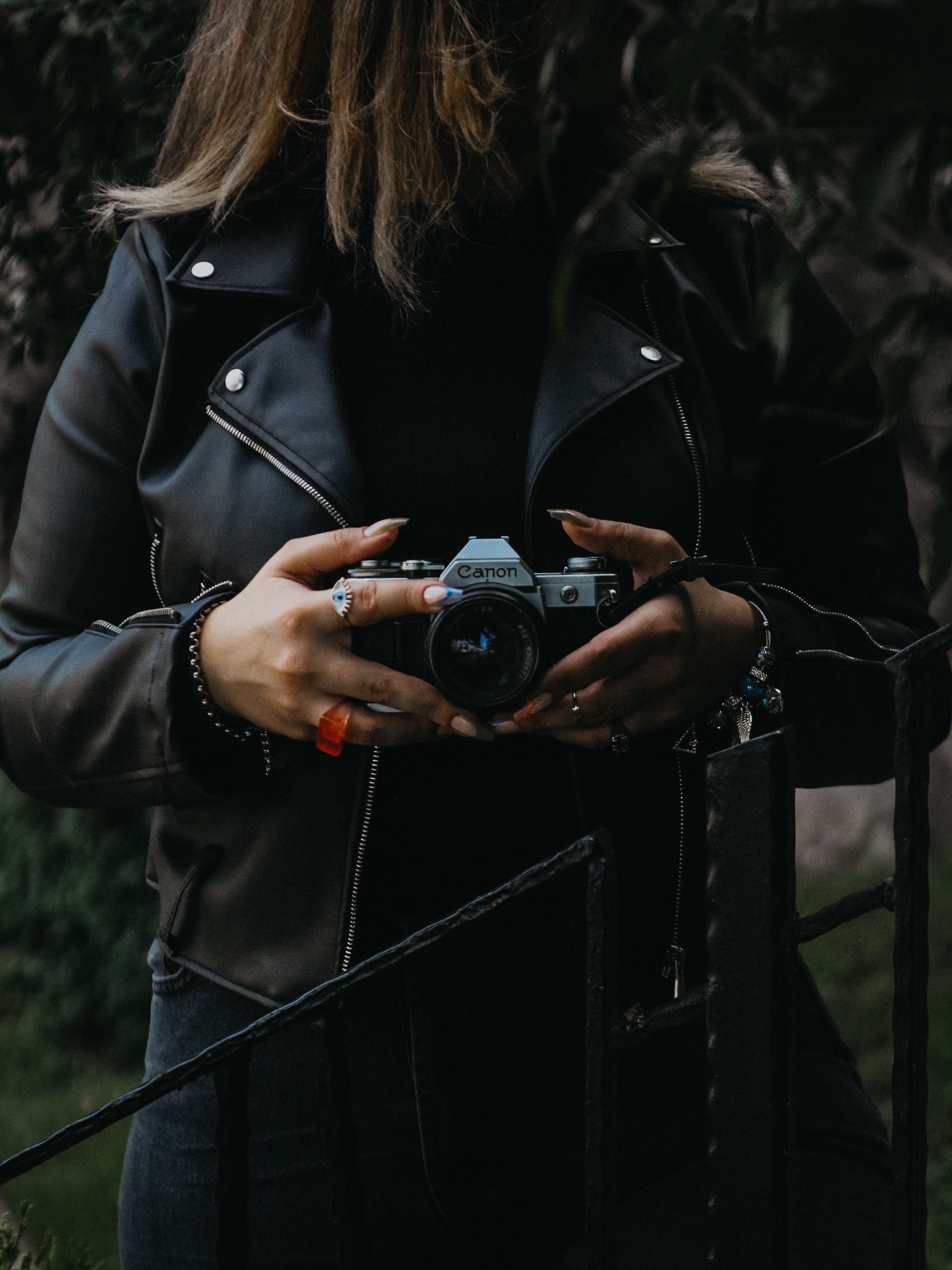 Woman in leather jacket holding retro camera