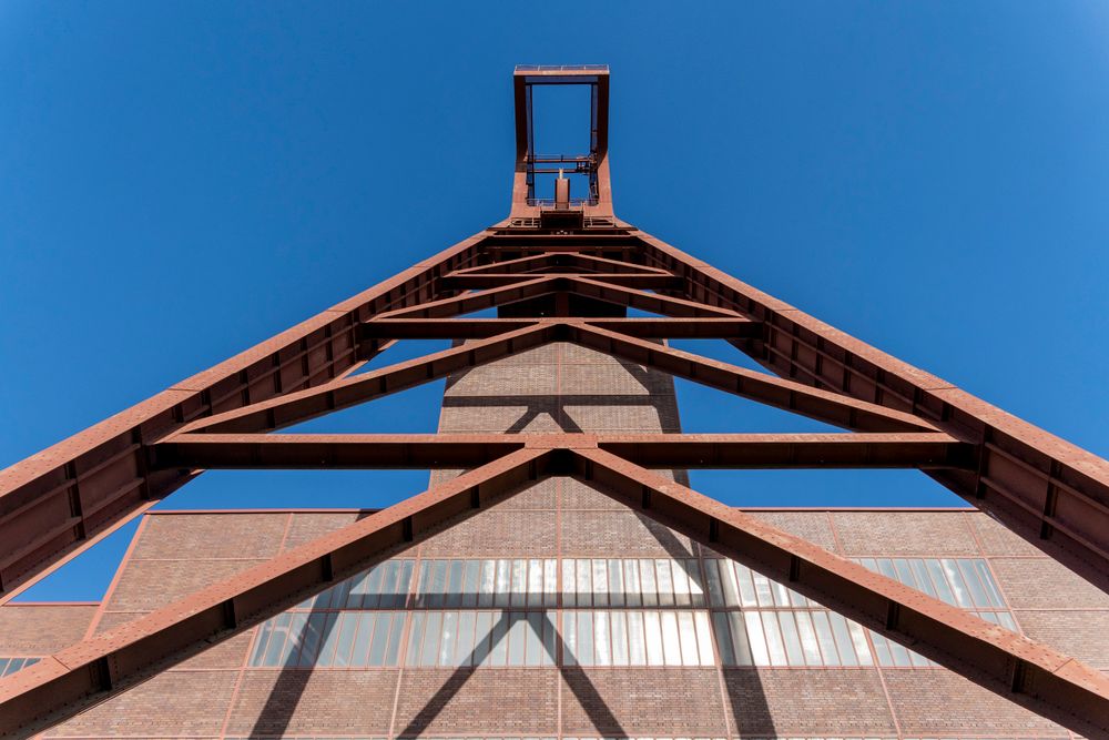 Steel roof structure seen from below against an open sky.