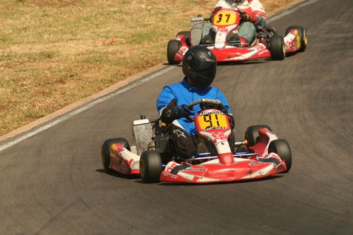 Free Intense kart racing action featuring multiple drivers on an outdoor track. Stock Photo