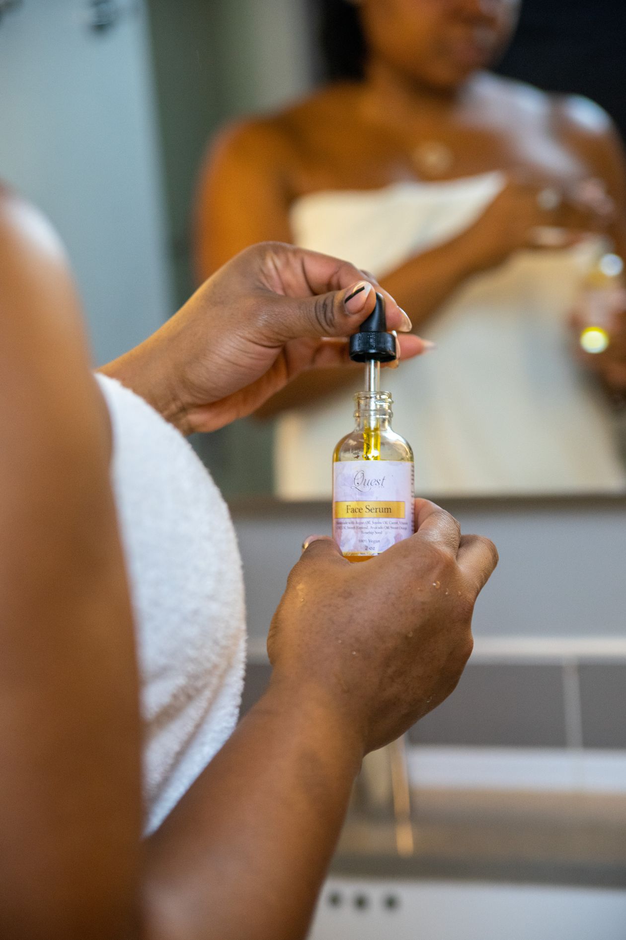 Gros plan d'une femme appliquant quelques gouttes de sérum sur son visage à la pipette