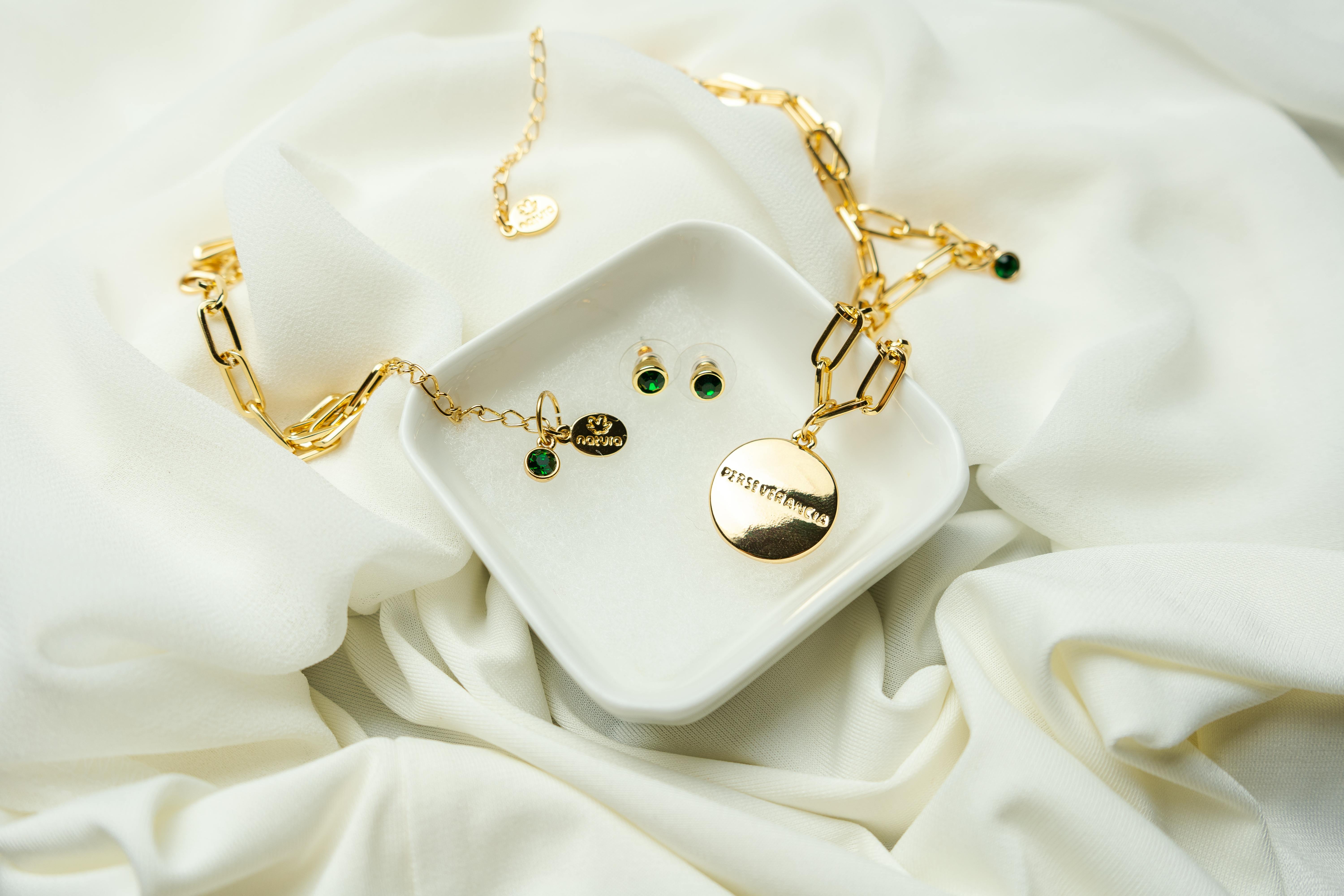 gold necklace in a white ceramic bowl