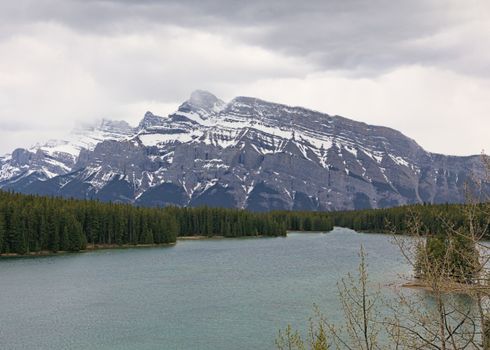 Snow-capped mountains against a serene lake in Banff National Park, Canada.
