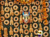A vibrant display of traditional Mexican bread with a colorful Mexican mask.