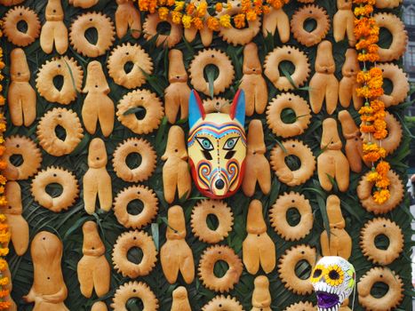 A vibrant display of traditional Mexican bread with a colorful Mexican mask.