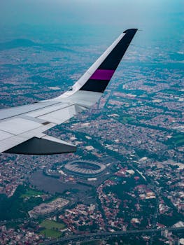 Stunning aerial view over Ciudad de México with an airplane wing in the foreground.