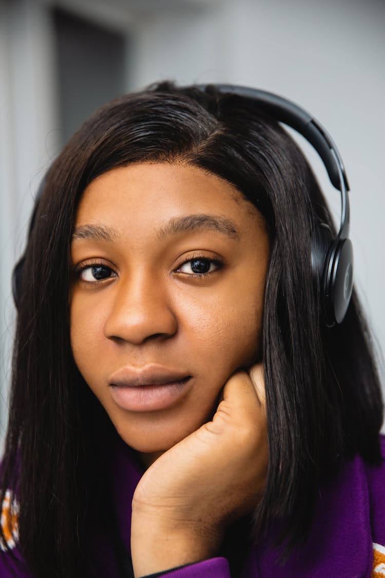 A Woman In Purple Shirt Wearing Black Headphones