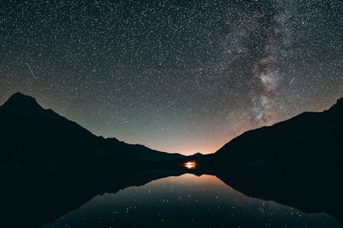 Silhouette Photo of Mountain and Calm Body of Water