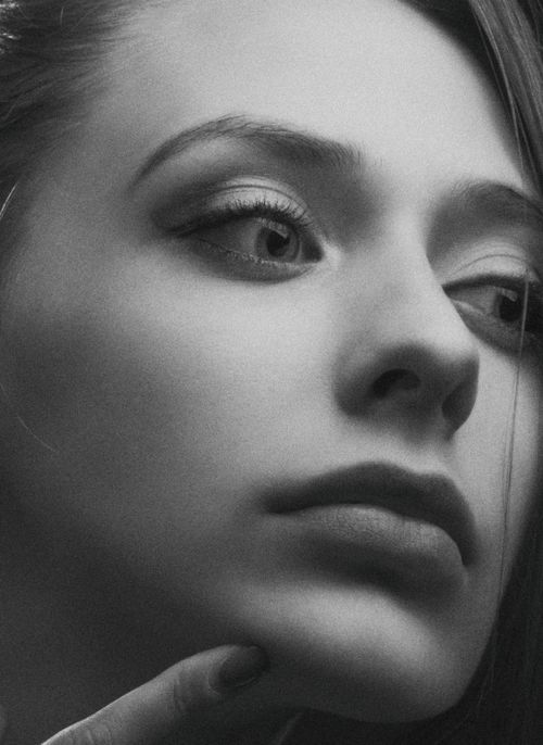 Free Artistic black and white close-up of a woman's thoughtful expression. Stock Photo
