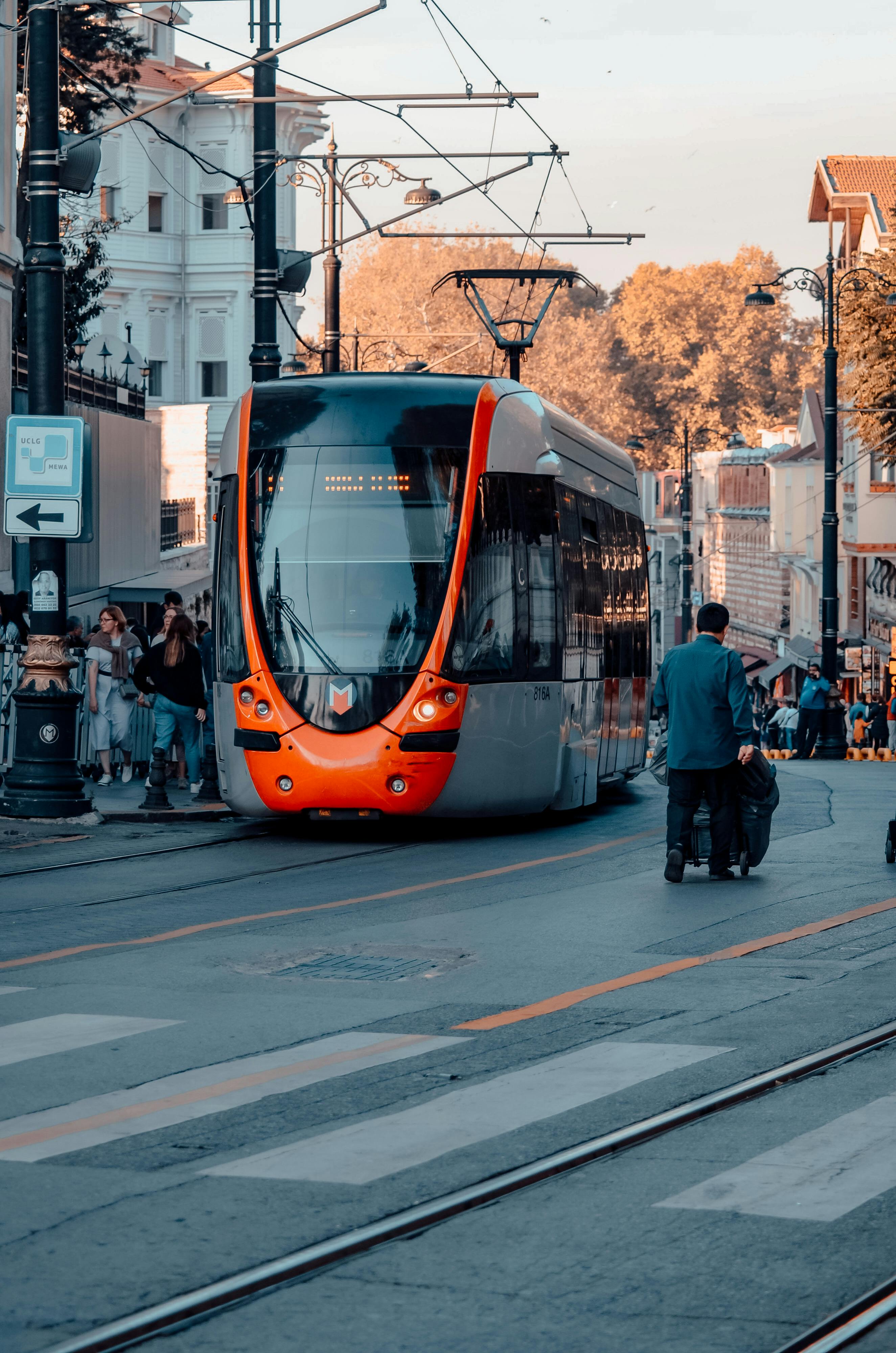 Free A vibrant urban street scene in Istanbul showcasing a modern tram surrounded by people and architecture. Stock Photo