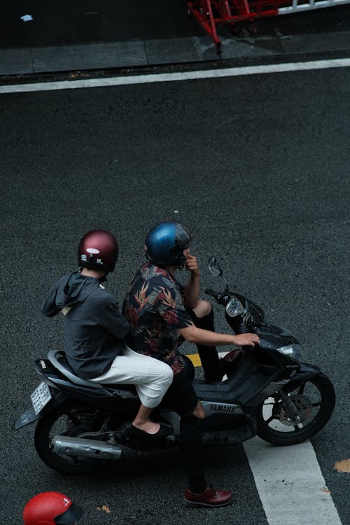 People in Helmets Riding Motorbike on City Street