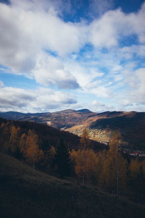 Free Breathtaking landscape of mountains and trees beneath a vivid blue sky in autumn. Stock Photo