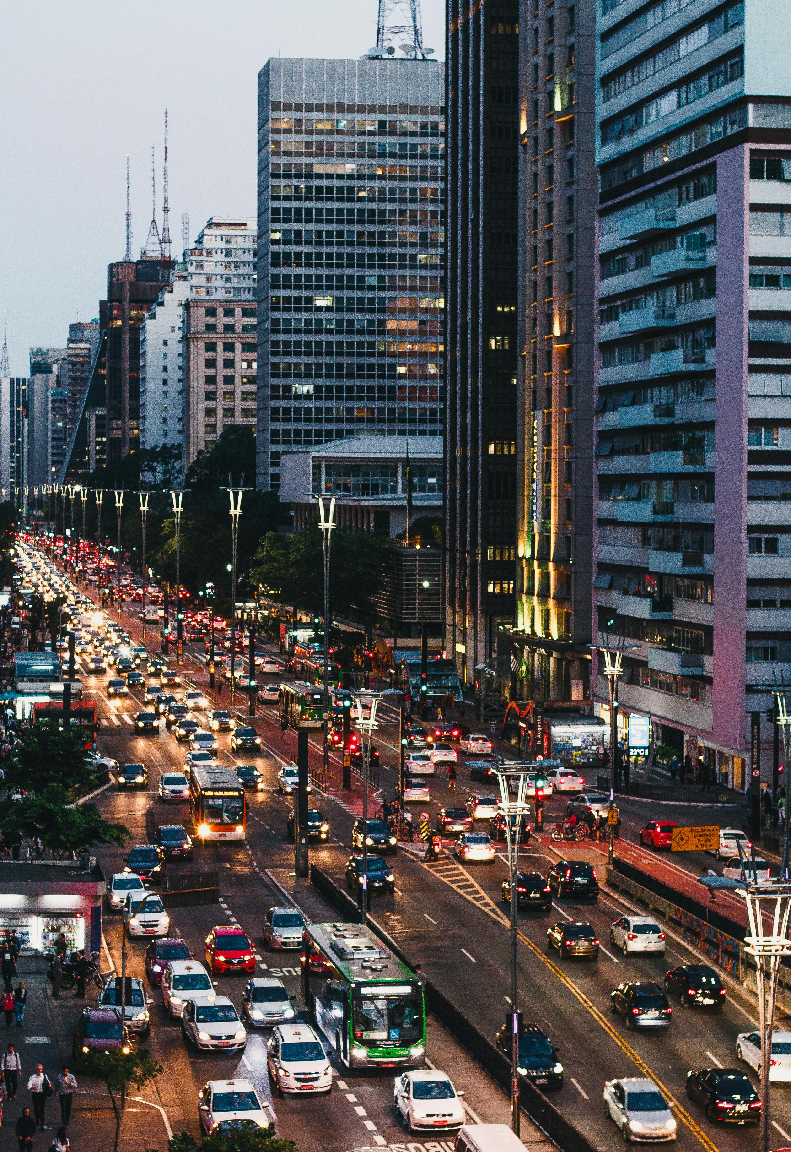 A dynamic evening cityscape showcasing busy traffic and modern skyscrapers under the twilight sky.