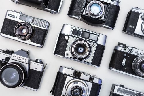 Free A top-down view of various vintage cameras displayed on a white background. Stock Photo