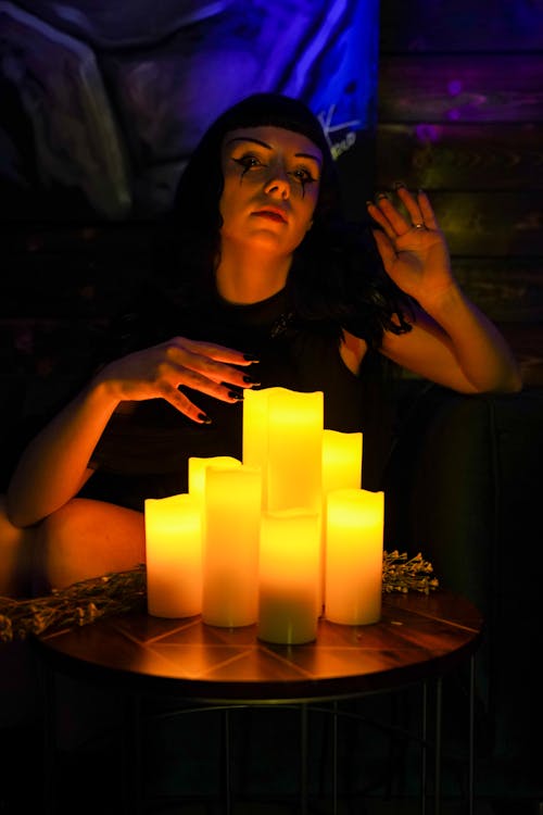 Woman Sitting in front of Lit Candles