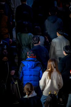 A diverse group of people with jackets standing on a winter evening in Seoul.
