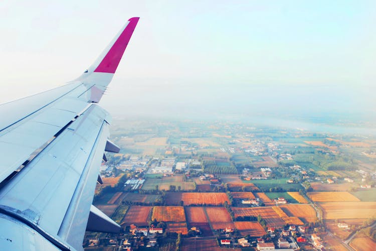 An Airplane Flying Over Agricultural Land