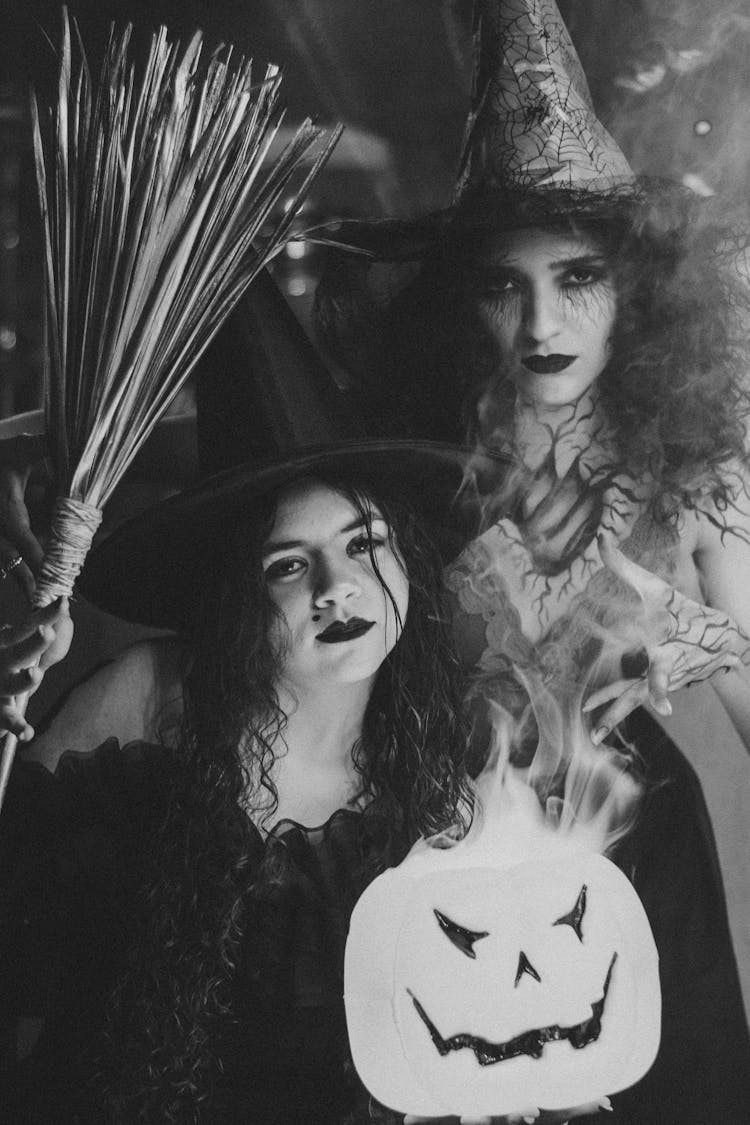 Black And White Portrait Of Witches With Broom And Glowing Pumpkin