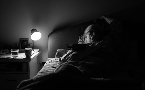 Free Grayscale Photo of Elderly Woman Lying on Bed Stock Photo
