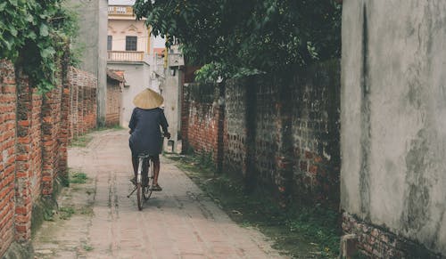 Person Riding Bicycle in the Middle of an Alley