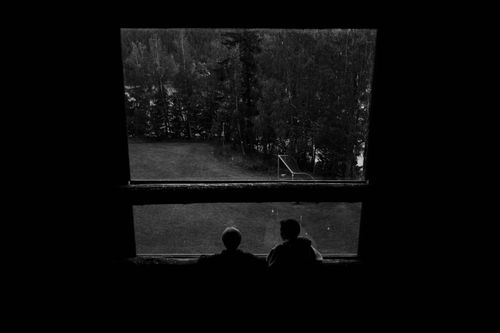 Free Two individuals silhouetted against a forest view from a window, in black and white. Stock Photo