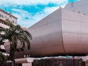 加纳阿克拉有一座引人注目的现代建筑，蓝天下矗立着一棵棕榈树