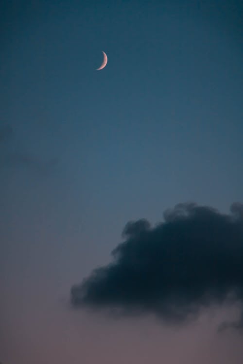 Crescent Moon in the Sky Above a Dark Clouds