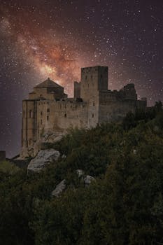Milky Way illuminating Loarre Castle's ancient walls under a starlit sky.
