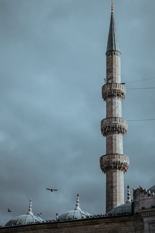 Gray Concrete Minaret of a Mosque Under Dark Cloudy Sky