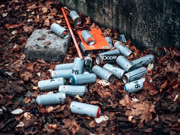 Photo Of Empty Spray Cans On The Ground